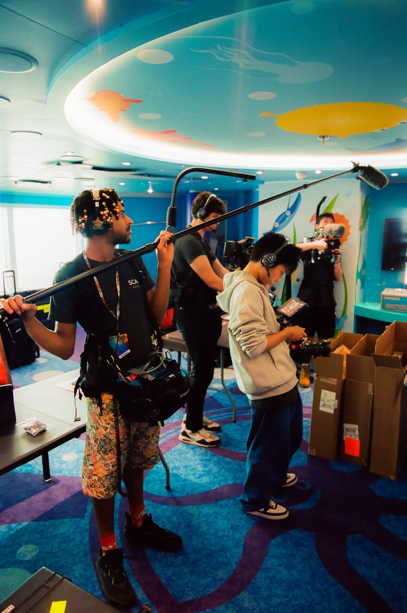 Sound and camera crew filming in a kids club aboard the ship